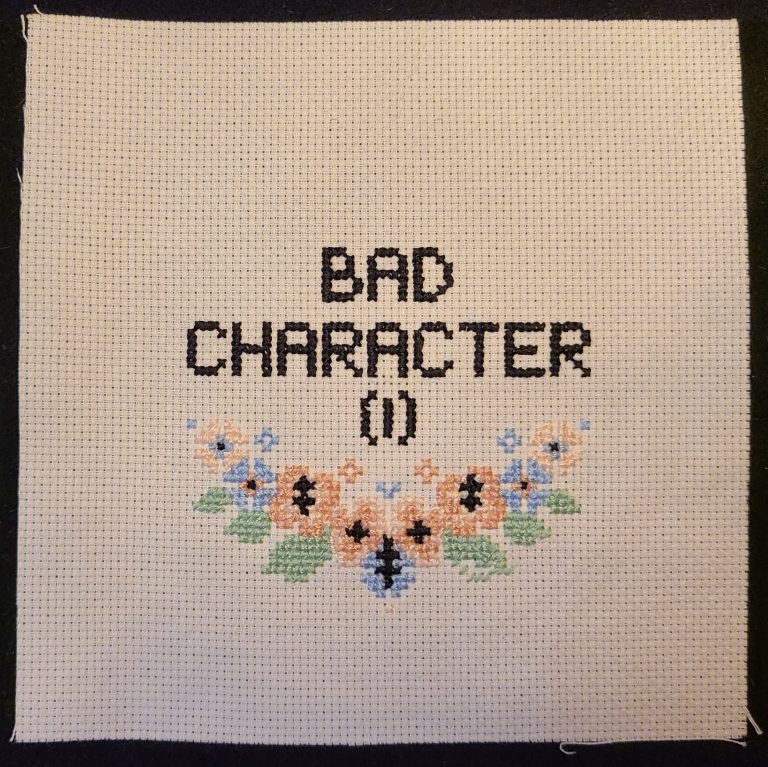 A cross-stitch piece that reads 'bad character (1)' along with flowers with the subfield character