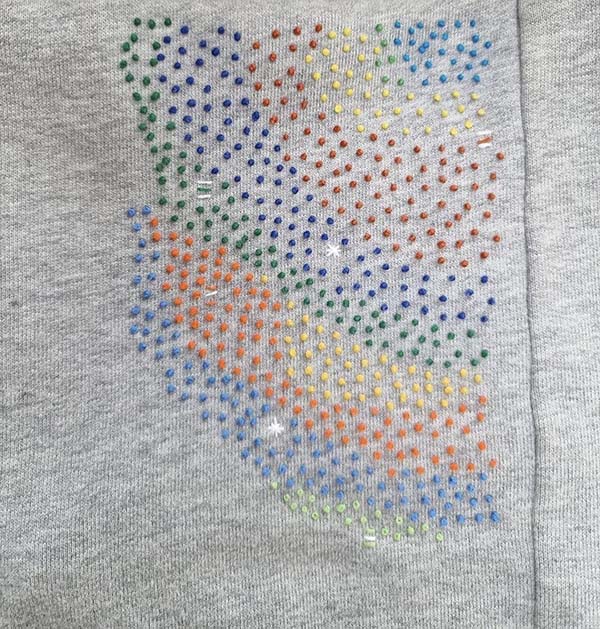 A gray knit material embroidred with French knots